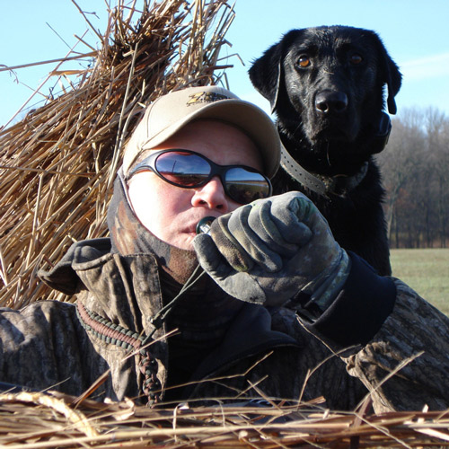 Waterfowl hunter hunting in a blind with their dog